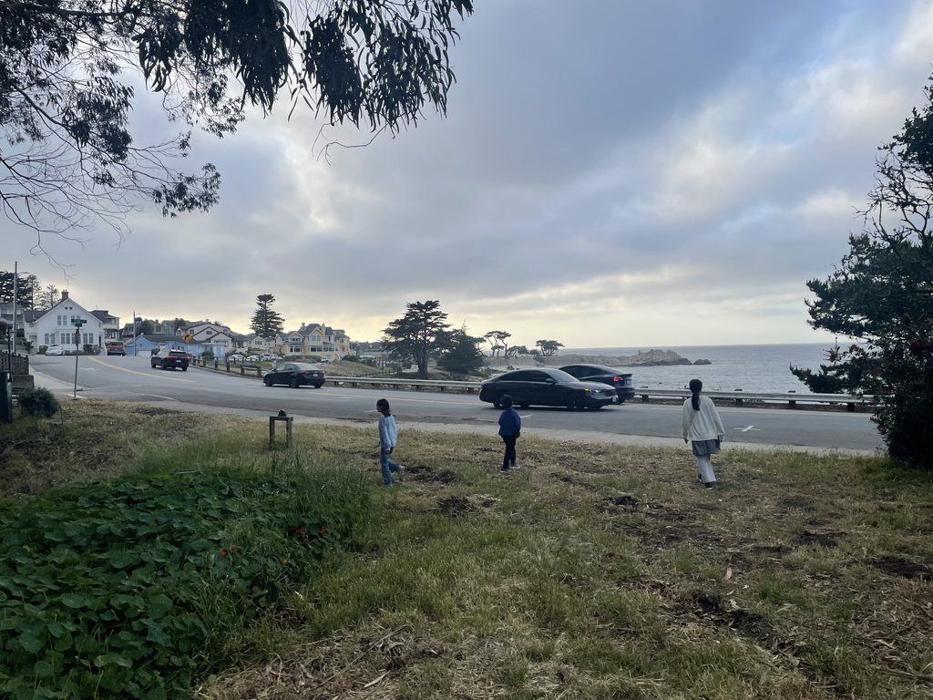 モントレーの海へ向かって歩く家族と海岸沿いの街並み